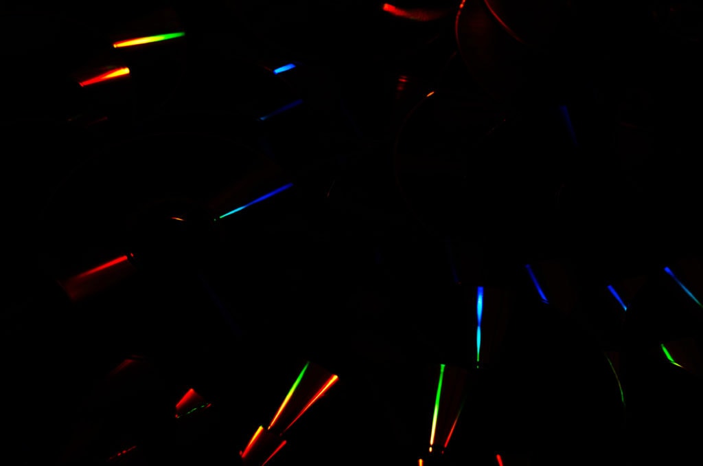 Abstract dark background of rainbow iridescent light streaks. Prismatic color light streaks
