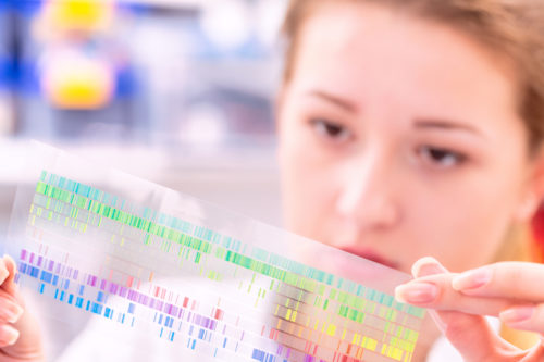 Young woman examines a spectroscopy picture in a quantum physics